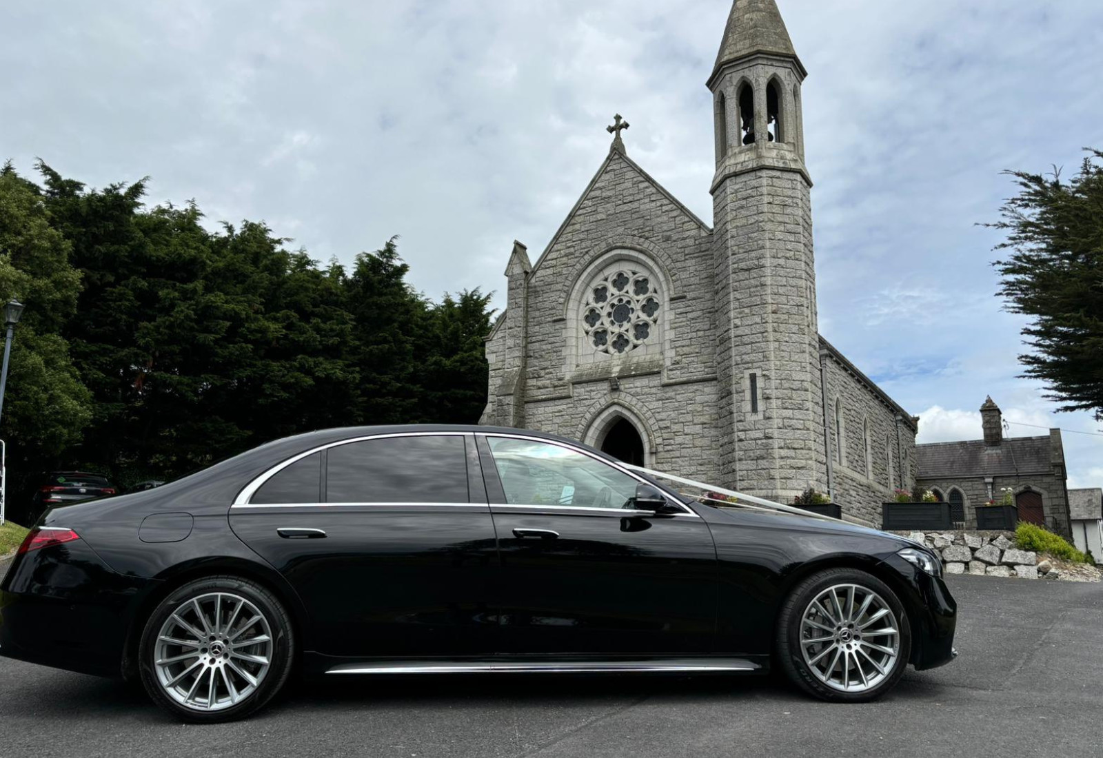 a sleek luxury vehicle outside of a church for wedding chauffeur service